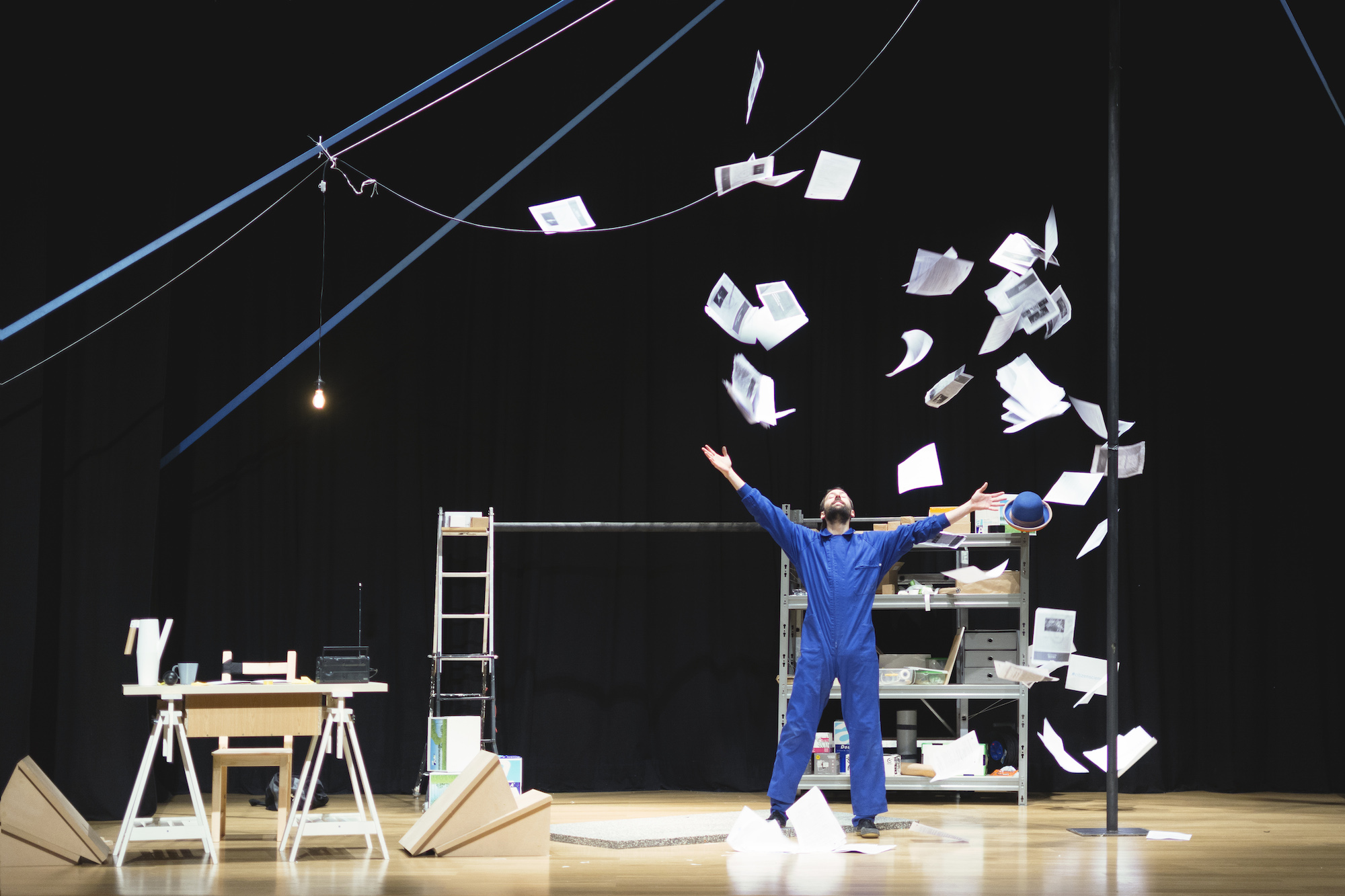 Hombre lanzando papeles al aire en el escenario