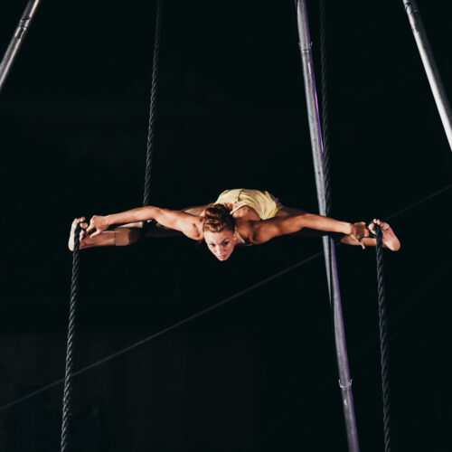 Mujer realizando acrobacias en dos cuerdas verticales